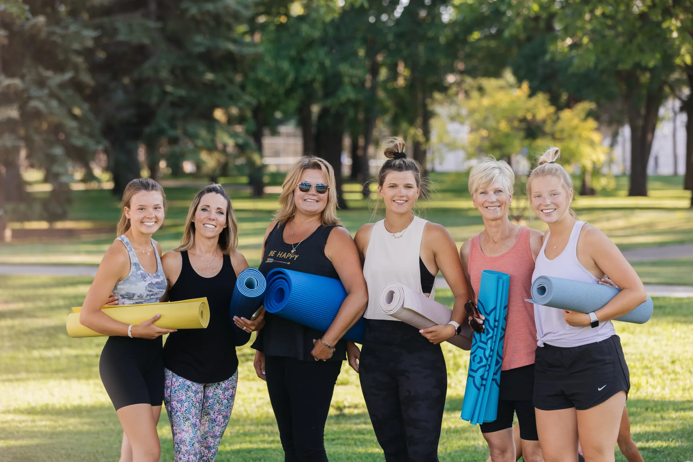A group of women doing yoga in a park.