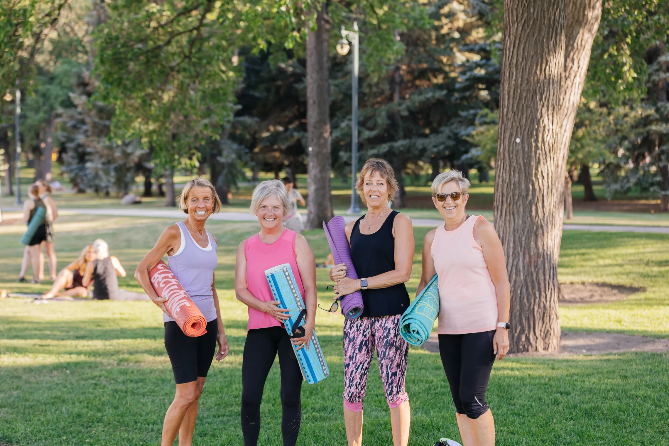 Four women enjoying yoga in a park.