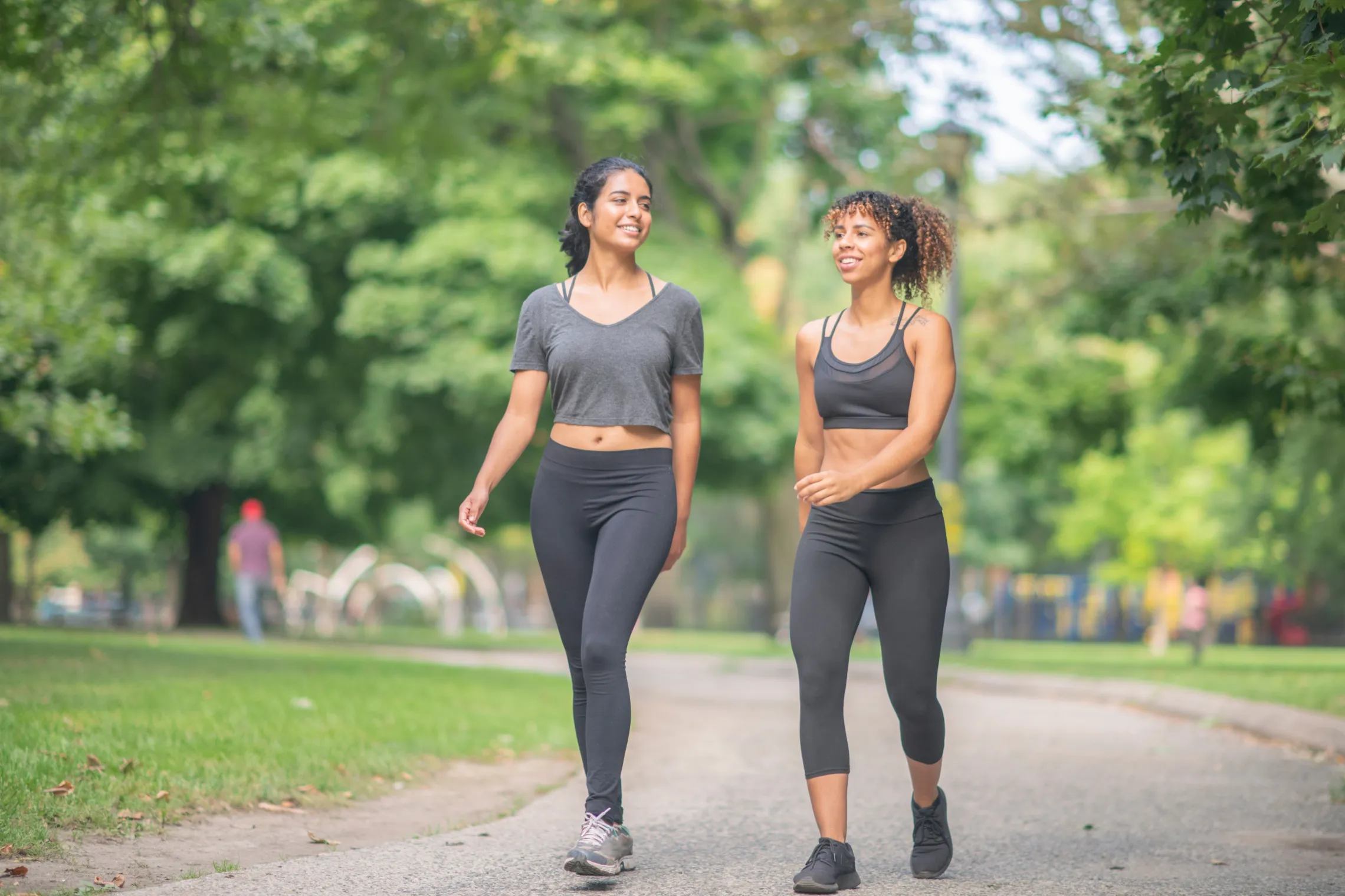 Two women walking through the park together