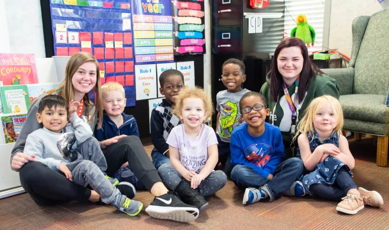 Photo shows a class at Fercho Learning Center with two staff members next to them
