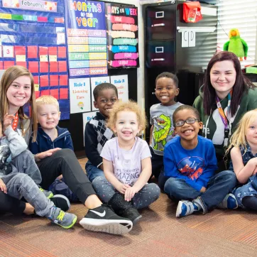 Photo shows a class at Fercho Learning Center with two staff members next to them